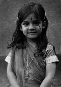 Black and white photo of Ulcca Joshi Hansen as young child dressed in traditional Indian garb.