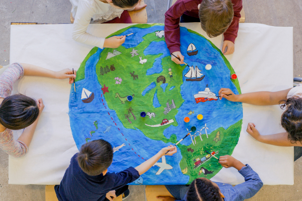 aerial photo of children painting a globe