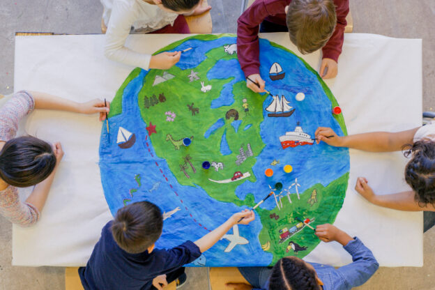 aerial photo of children painting a globe