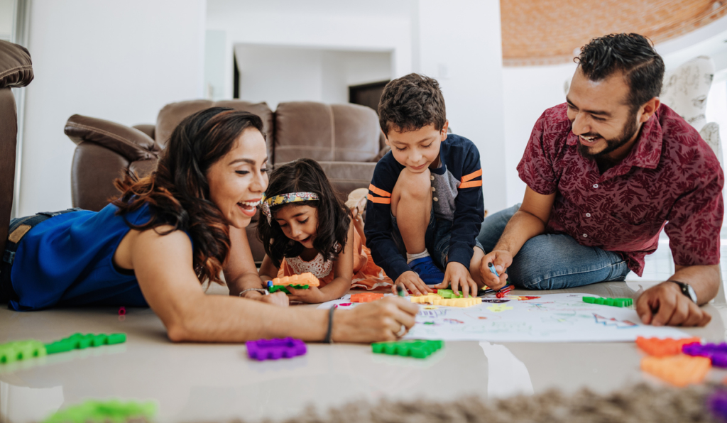 family drawing together on the floor in the living room