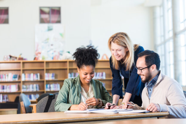 Group of educators around a table in a library