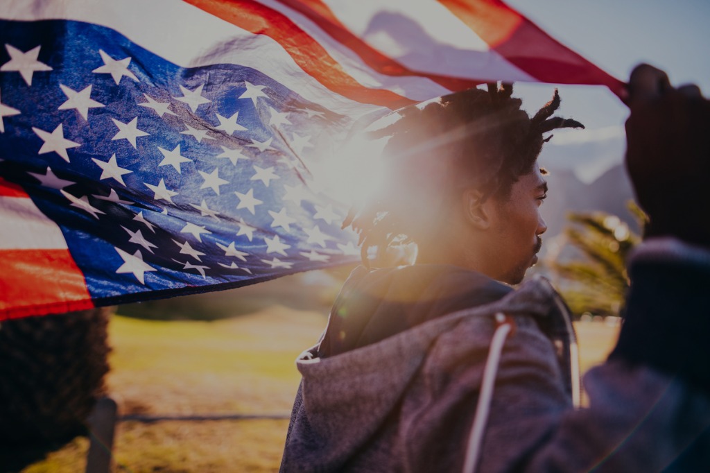 Learner holding American flag during sunset