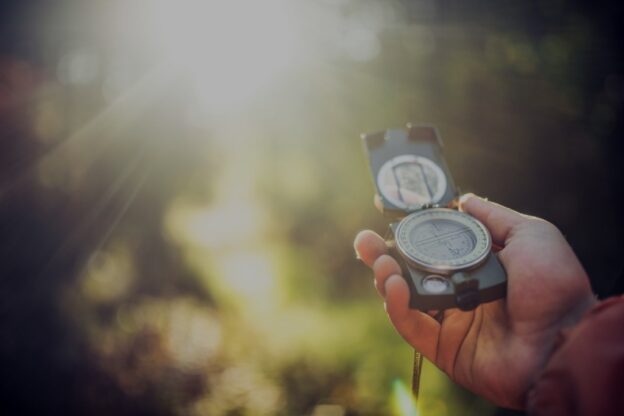 close up of a hand holding a compass