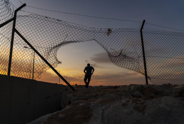 man running through open fence