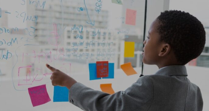 young learner in front of window with marker text and post-it notes