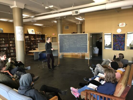 learners sitting on couches around a blackboard at the City of Bridges High School