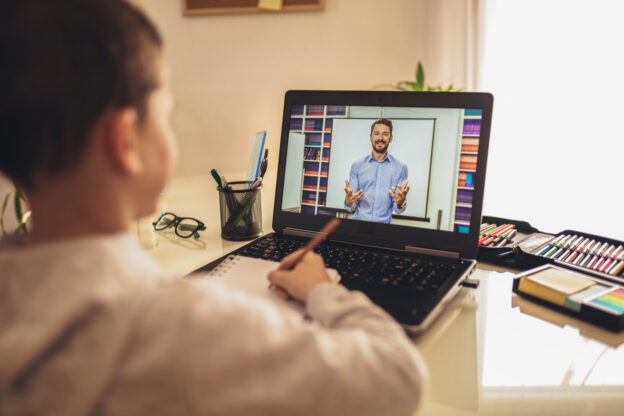 Distance learning online education. A schoolboy boy studies at home and does school homework. A home distance learning.