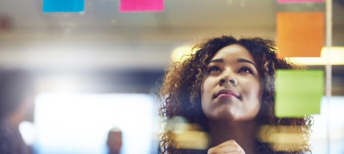 Shot of a young woman having a brainstorming session with sticky notes at work