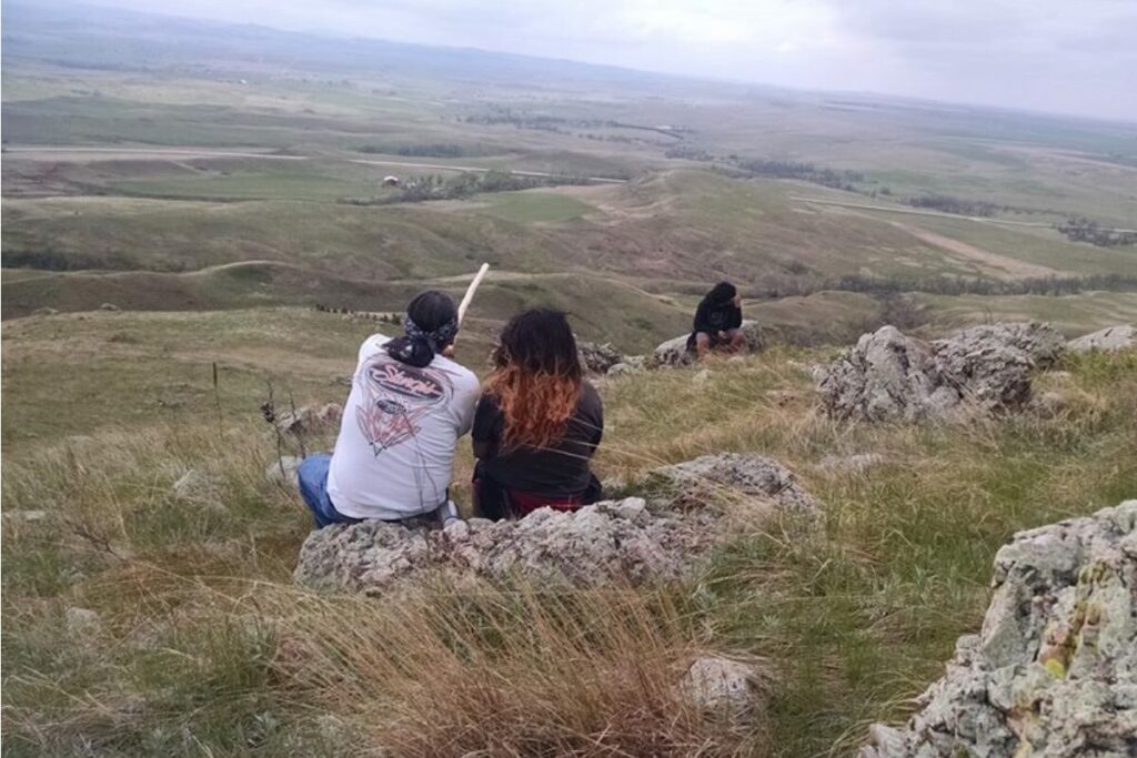 photo of the back of two learners looking out in a field