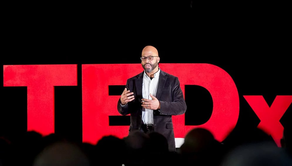 Dr. Craig Waleed on stage in front of a TedX sign