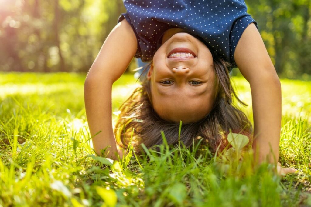 young learner doing a handstand on the grass