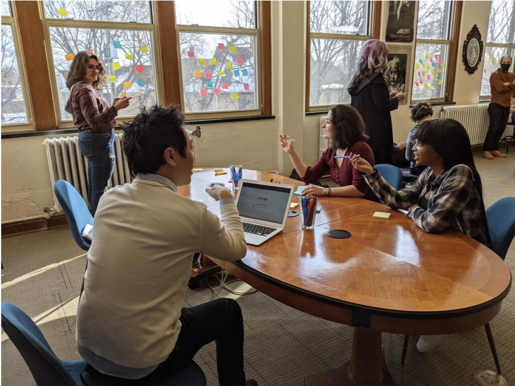 high school learners sitting around a table working with post it notes