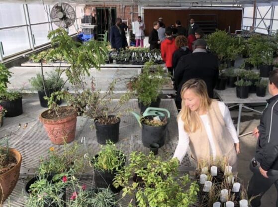 Emily Liebtag with a group of learners in a greenhouse