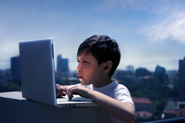 photo of young learner on a laptop outside