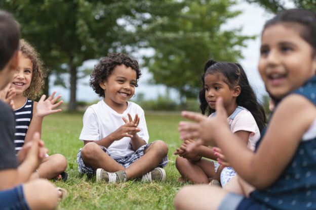 photo of young learners sitting in a circle on the grass