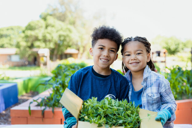 young learners posing in a community garden