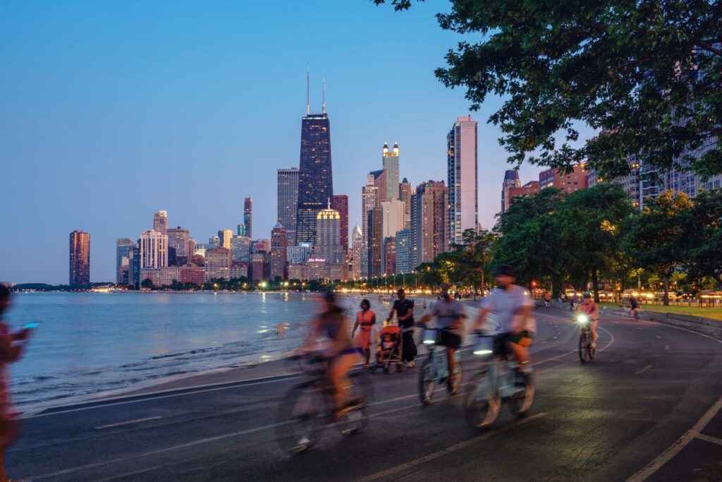 Blurred images of people riding bikes with a city scape in the background