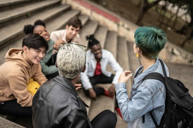 young learners sitting together on concrete steps