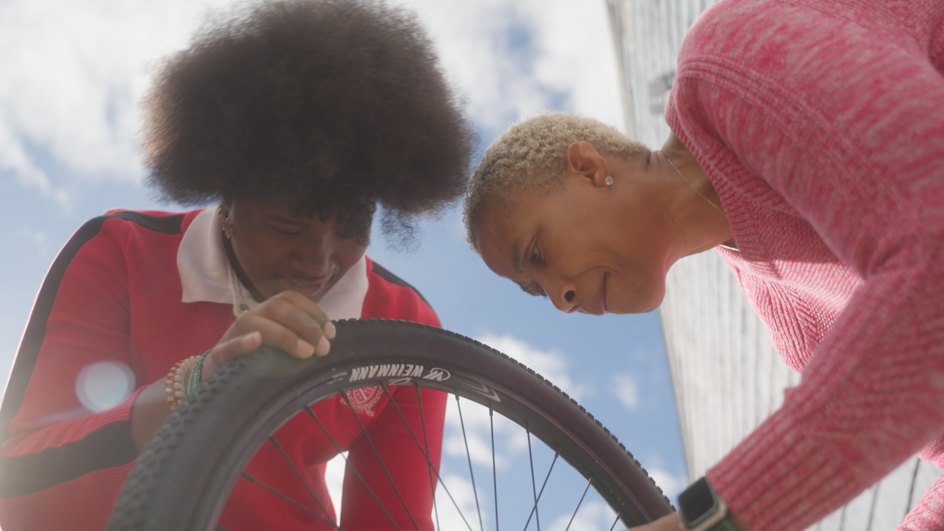 learner and educator reparing a bicycle wheel