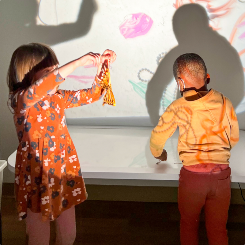 School with a School young learners playing in front of a projected screen