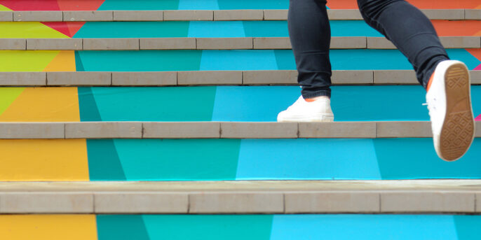 Person climbing colorful steps