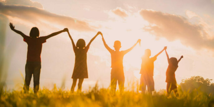 young learners outside holding hands