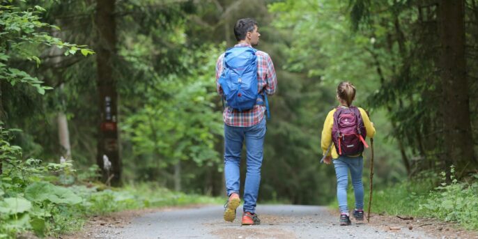 parent and child walking on hiking trail