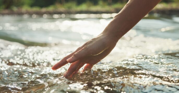 hand touching running water