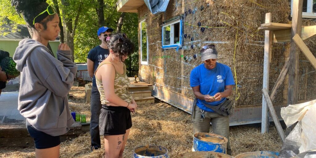 Learners outside with mentor from Habitat for Humanity learning about building 